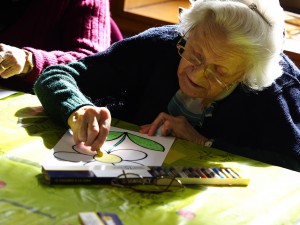 Fotografía en la que se puede ver una anciana pintando en nuestros talleres