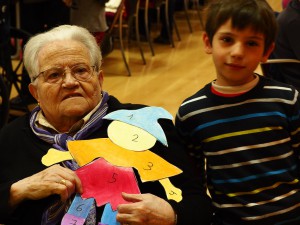 Fotografía en la que se pueden ver a un niño y una anciana participando en nuestros programas especiales